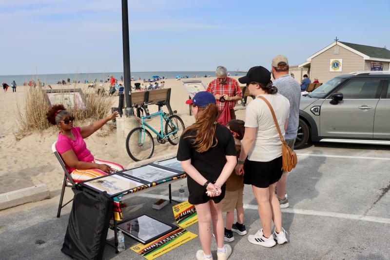 Trina Brown Hicks, left, talks to visitors about the history of Johnnie Walker Beach. Brown represented the Lewes African American Heritage Commission, one of several groups that set up tables at the beach bonfire.